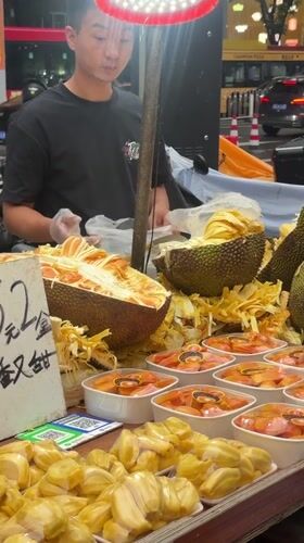 Jackfruit vendor and parked motorbikes on a Haizhu street
