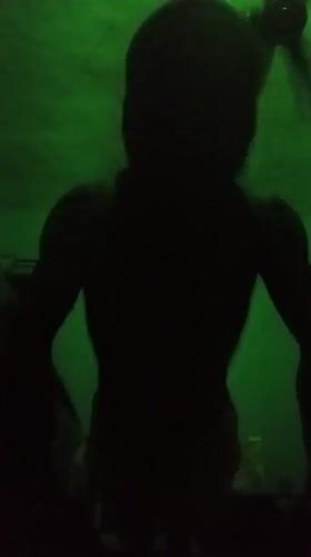 Person silhouetted in green-lit room in Nkpor, Nigeria