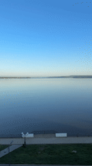 Man in swim trunks carries blue object near Votkinsk waterfront
