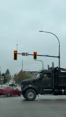 Black dump truck crosses wet intersection in New Westminster