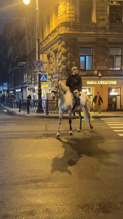 Horse rider and motorcycles share wet Saint Petersburg streets