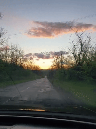 Driver captures sunset journey on damaged Ukrainian road