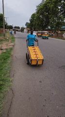 Man pulls water cart through Jos street intersection