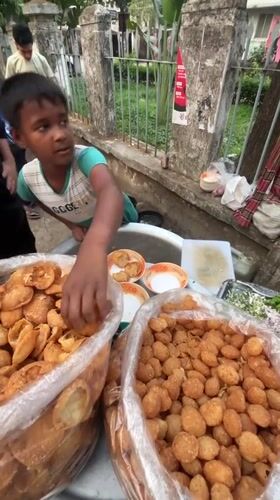 Young vendor serves pani puri at Dhaka street stall