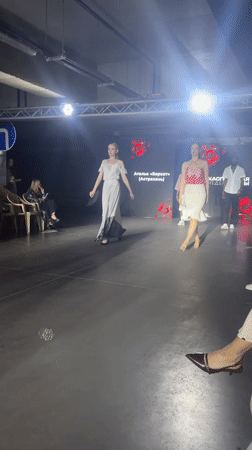 Fashion show features models in white dresses in Tri Protoka