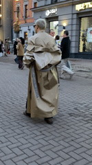 Man in distinctive trench coat walks through Moscow plaza