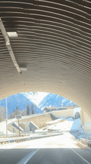 Vehicle exits tunnel near snow-covered mountains in Estosadok, Russia