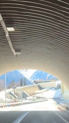Vehicle exits tunnel near snow-covered mountains in Estosadok, Russia