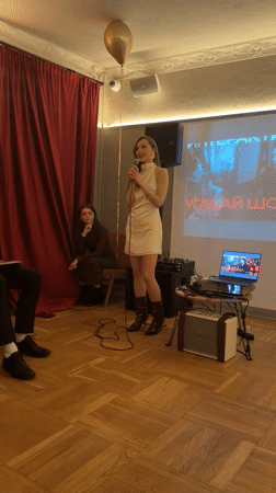 Woman delivers speech at Moscow event with projection screen
