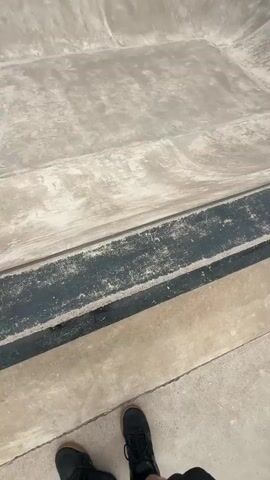 A skateboard park is captured in a series of close-up shots and wider views. The concrete park features various ramps and bowls with metal edging. The first shot focuses on the ground with a shoe in the lower corner. The subsequent shots reveal the entire park, with a person in a dark shirt visible in one of the ramps, appearing to be about to skate. Trees and grassy areas surround the park. The sky is cloudy.