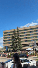 Crowd gathers behind barricades in Pernik to observe passing vehicle