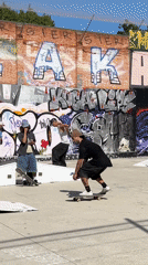 Skateboarder performs tricks at Barcelona skate park near stone arches