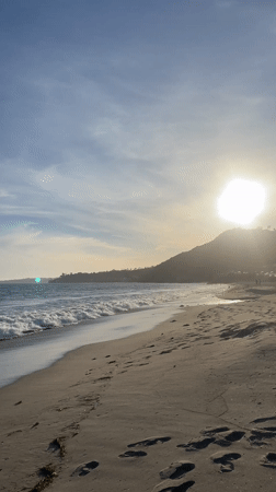 Sunset beach scene captured in Malibu with waves and footprints