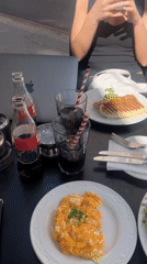 Woman photographs brunch at sunny London outdoor cafe
