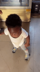 Toddlers play together on tiled floor in Nigerian home