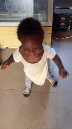 Toddlers play together on tiled floor in Nigerian home