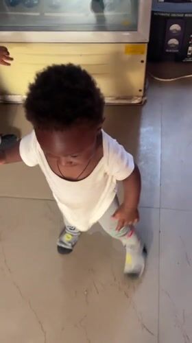 Toddlers play together on tiled floor in Nigerian home
