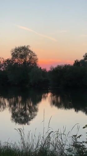 Sunset captured over tranquil lake in Veauchette, France