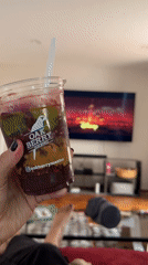Person enjoys layered smoothie while relaxing on couch in Mexico City