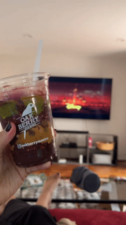 Person enjoys layered smoothie while relaxing on couch in Mexico City