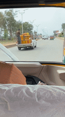 Pickup truck transports yellow containers through Bukuru, Nigeria streets