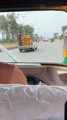 Pickup truck transports yellow containers through Bukuru, Nigeria streets