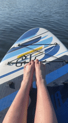 Woman enjoys sunny afternoon paddleboarding on Russian lake
