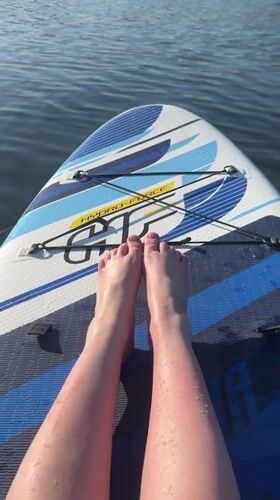 Woman enjoys sunny afternoon paddleboarding on Russian lake