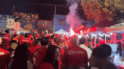 Corona-shirted crowd gathers with tents, flares in Toluca street