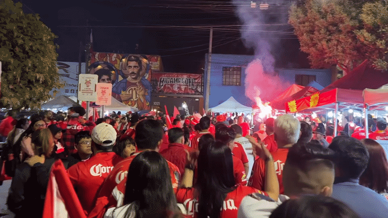 Corona-shirted crowd gathers with tents, flares in Toluca street