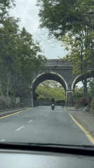Vehicles pass through stone archway in Funchal