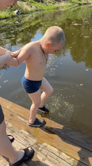 Child prepares for swim with adult supervision in Zhigalki