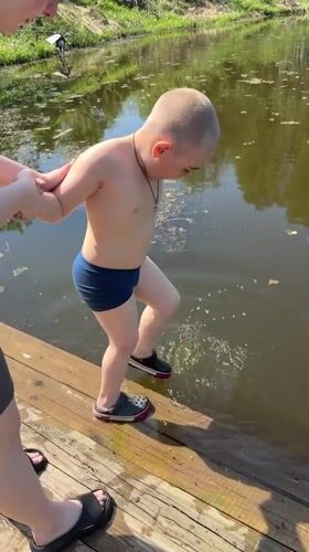 Child prepares for swim with adult supervision in Zhigalki