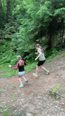 Young runners jog through pine forest in Chaikovsky, Russia