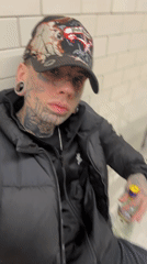 Tattooed person displays gin bottle in Buenos Aires