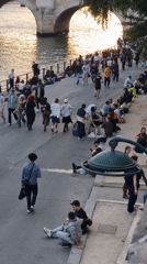 Evening crowds gather along Paris bridges and riverfront