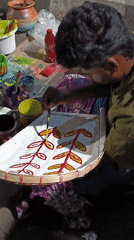 Street artisans hand-paint decorative bamboo crafts in Dhaka