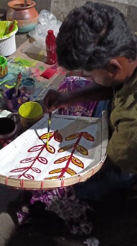 Street artisans hand-paint decorative bamboo crafts in Dhaka