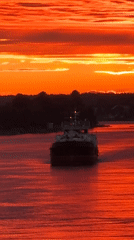Fiery sunset over the Svir River with a barge passing through