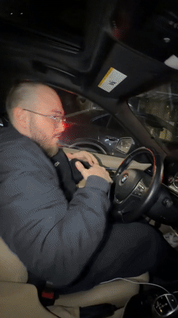 Driver enjoys music in BMW during rainy Tbilisi evening