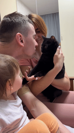 Russian family spends evening with black cat in domestic setting