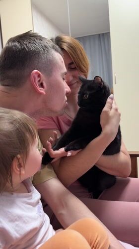 Russian family spends evening with black cat in domestic setting