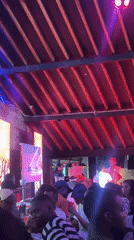 Late-night social gathering documented at bar with distinctive lighting