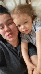 Mother and toddler share quiet morning moments in bed