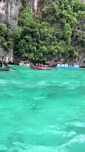 Longtail boats and swimmers among Ao Nang's karst cliffs