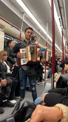 Accordionist busks on Sofia Metro with coffee cup balancing act