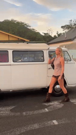 Young adults socialize with drinks near van in Thirroul