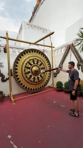 Tourists ring ceremonial gong at Bangkok's Giant Swing shrine
