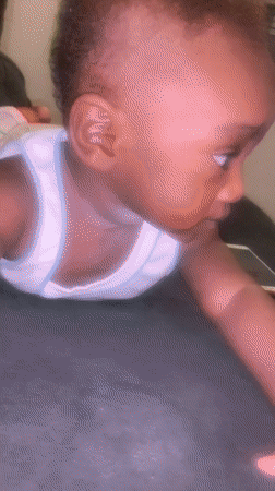Baby in white shirt observed lying on stomach in Nigeria