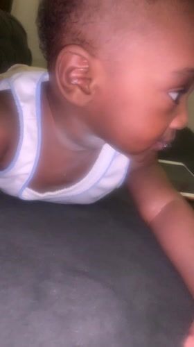 Baby in white shirt observed lying on stomach in Nigeria